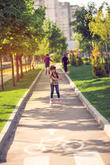 Attractive teenage girl roller skating in the park.