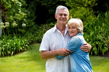 Portrait of senior couple embracing in back yard