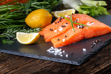 Salmon filet sliced on three parts with lime and herbs.