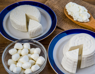 Fototapeta na wymiar Tzfat cheese, wheat, cottage cheese, and mozzarella balls on wooden deck for Shavuot celebration. 