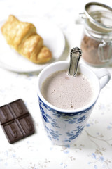 Hot chocolate and croissant for a breakfast.