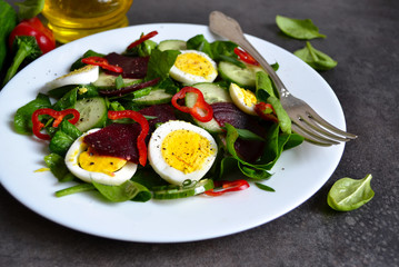 Vitamin salad with spinach, egg and beetroot on a black backgrou