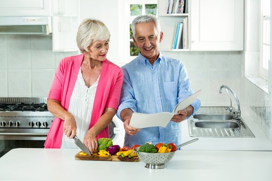 Happy senior couple with recipe book