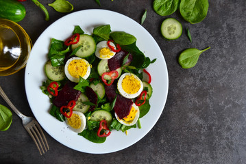 Vitamin salad with spinach, egg and beetroot on a black backgrou