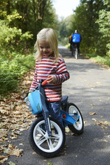 cute little girl riding runbike in summer

