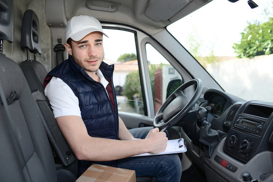 young delivery parcel service man with his commercial van on background