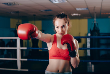 young boxing girl doing exercises on a boxing ring
