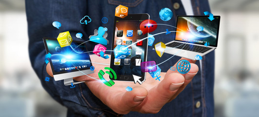 Businessman holding tech devices and icons applications © sdecoret