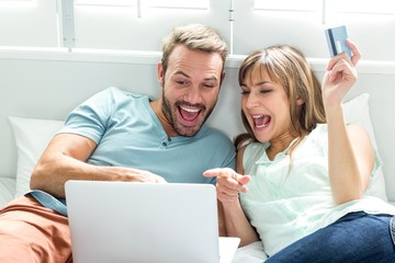 Couple screaming while looking in laptop