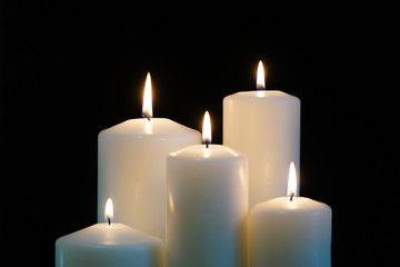 burning candles isolated on black background.