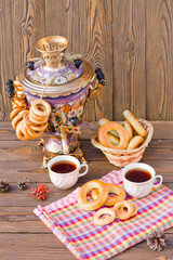 Samovar on a wooden background with bagels and tea