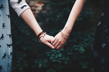 Close-up of two young women holding hands