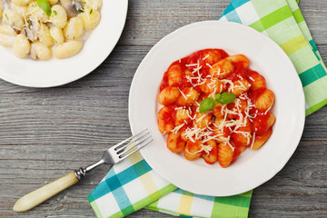 Serving gnocchi in tomato sauce and mushroom with cheese.
