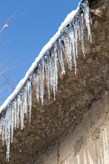 icicles on a roof of a house in winter