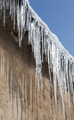 icicles on a roof of a house in winter
