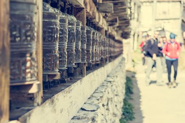 Obraz premium Buddhist praying wheels. Tourists blurred in the background.