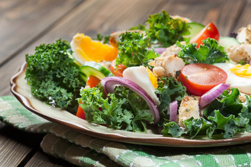 Fresh salad with chicken, tomatoes, eggs and lettuce on plate