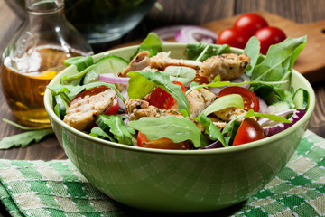 Fresh salad with chicken, tomatoes and arugula on plate
