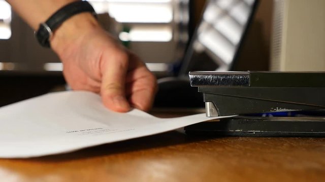 A frustrated business man stapling papers