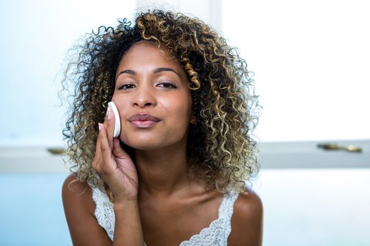 Young Woman Cleaning Her Face With Sponge