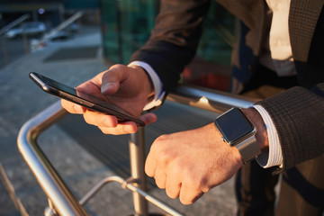 Hand with smart watch and a hand holding the cellphone