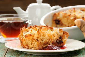 Panettone pudding and steaming hot black tea on shabby wooden