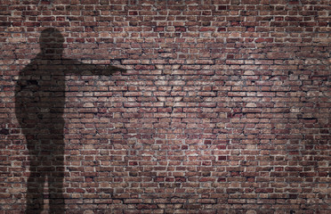 ombra di uomo che minaccia con una pistola