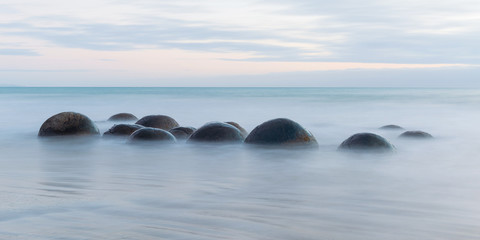 Fototapeta na wymiar Moeraki Boulders on the Koekohe beach, New Zealand during sunrise (long exposure)