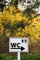 Toilet sign for man and female on white table in nature