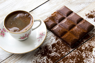 Turkish coffee with slices of chocolate on the wooden table 