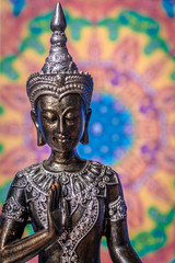 Buddha statue with soft colored mandala background