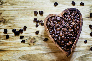 Arabica Coffee beans in a wooden bowl in the shape of a heart, a