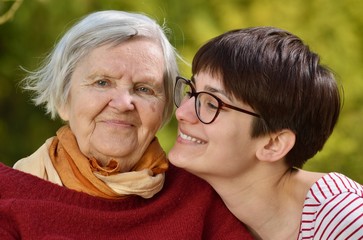 Grandmother and granddaughter. Young woman carefully takes care