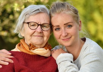 Grandmother and granddaughter. Young woman carefully takes care