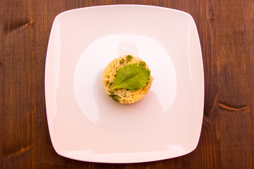 Rice with peas on a wooden table seen from above