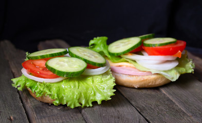 Sandwich with salad and other vegetables on old gray boards