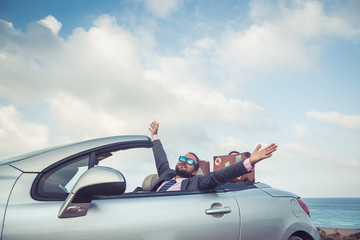 Businessman standing on a beach near car