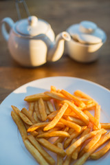 French fries with ketchup and on wooden table. Top view sunny evening