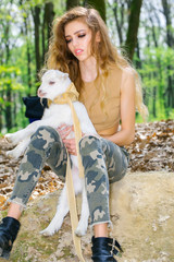Stylish girl with goat in forest