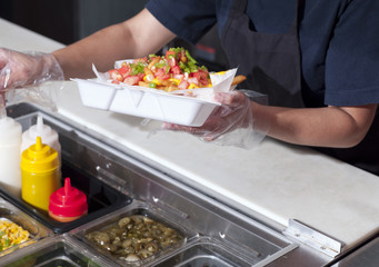 cropped image of chef packing burrito.