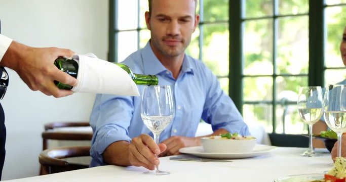 Businessman is being waited on a glass during lunch meeting