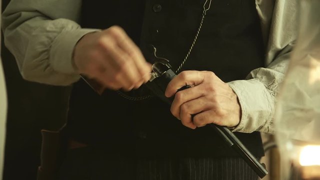 Bullets being loaded into an 1860 army pistol by a gunslinger or frontiersman from the American wild west time period.