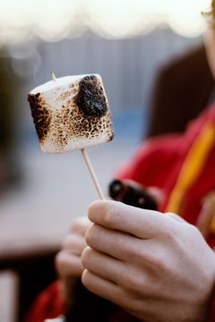 Hand holding a roasted marshmallow