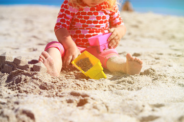 little girl play with toys on beach