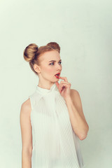 Close-up portrait of surprised beautiful girl with funny hairstyle.  Sly and scheming young woman...