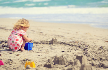 little girl play with sand on beach