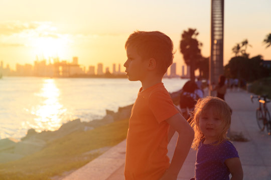 little boy and girl looking at sunset city