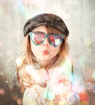 Child Blowing Colorful Sparkle Glitters