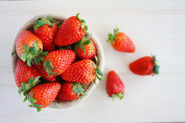 strawberries in small sack on wooden table background