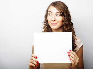 Naklejka premium Smiling young casual style woman showing blank signboard